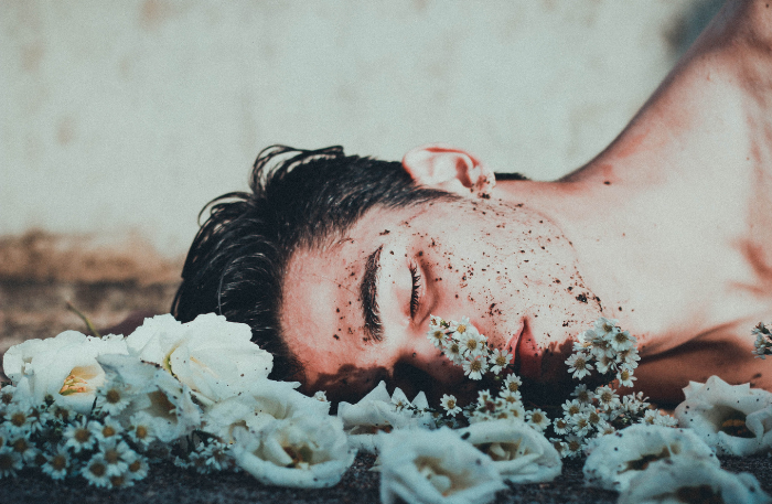 Ragazza distesa tra i fiori mentre dorme, immagine di vulnerabilità e abbandono